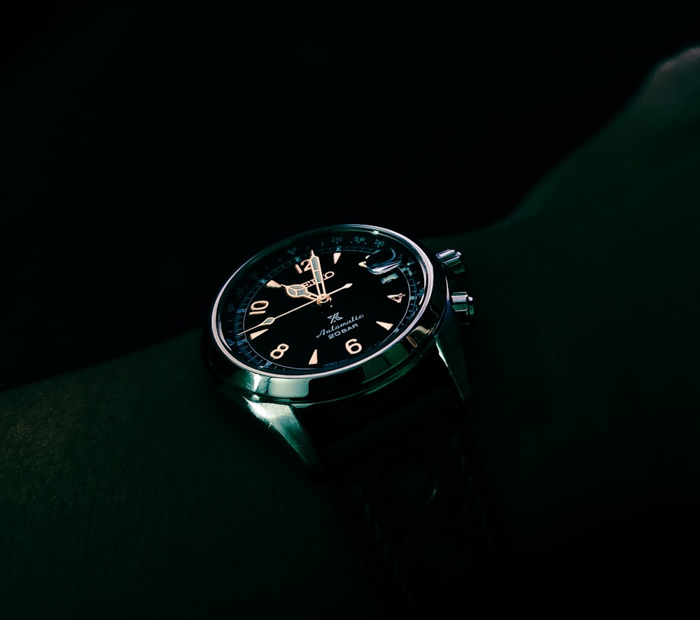 a watch that is on someones wrist in the dark