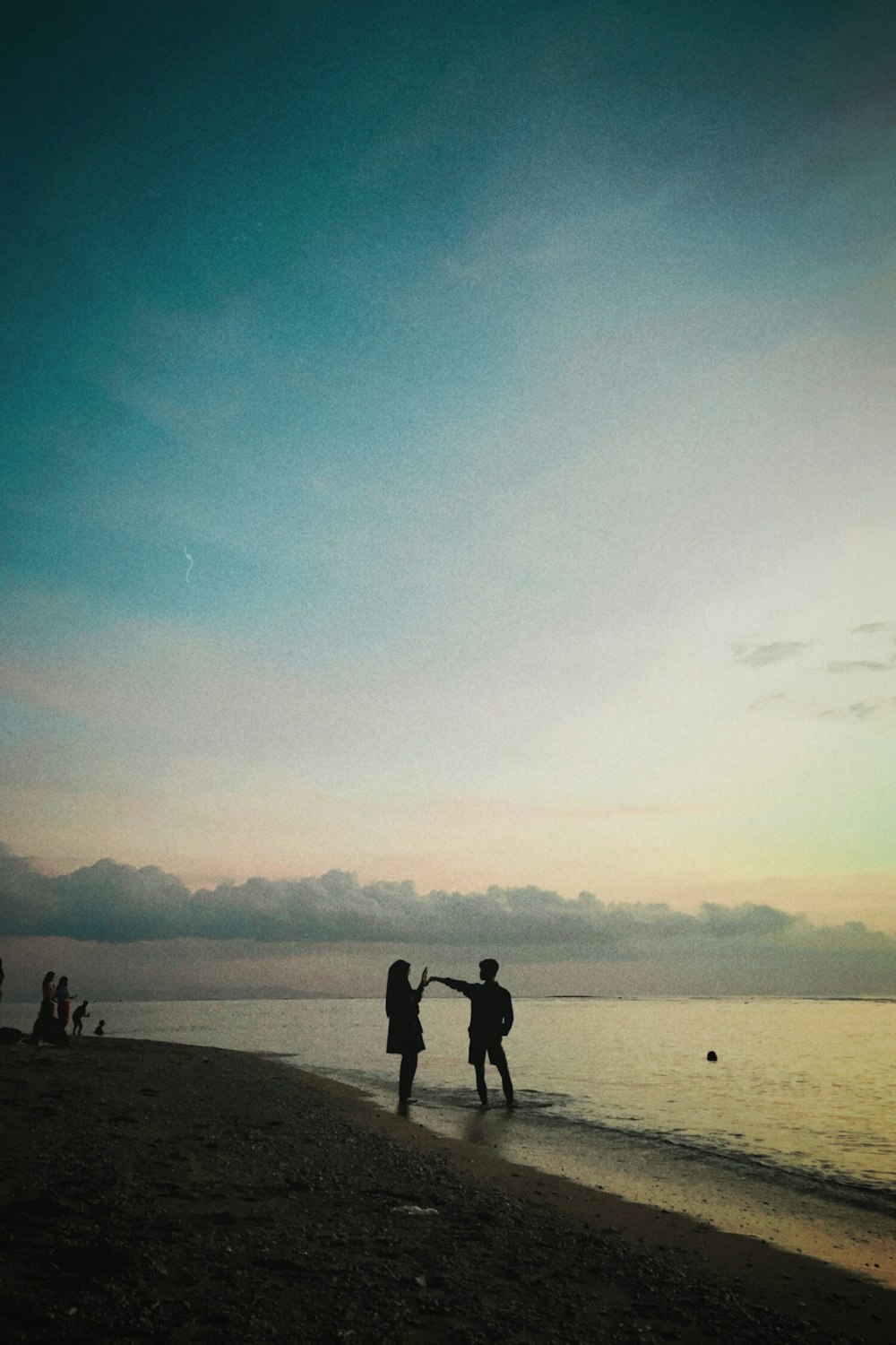 a couple of people standing on top of a beach