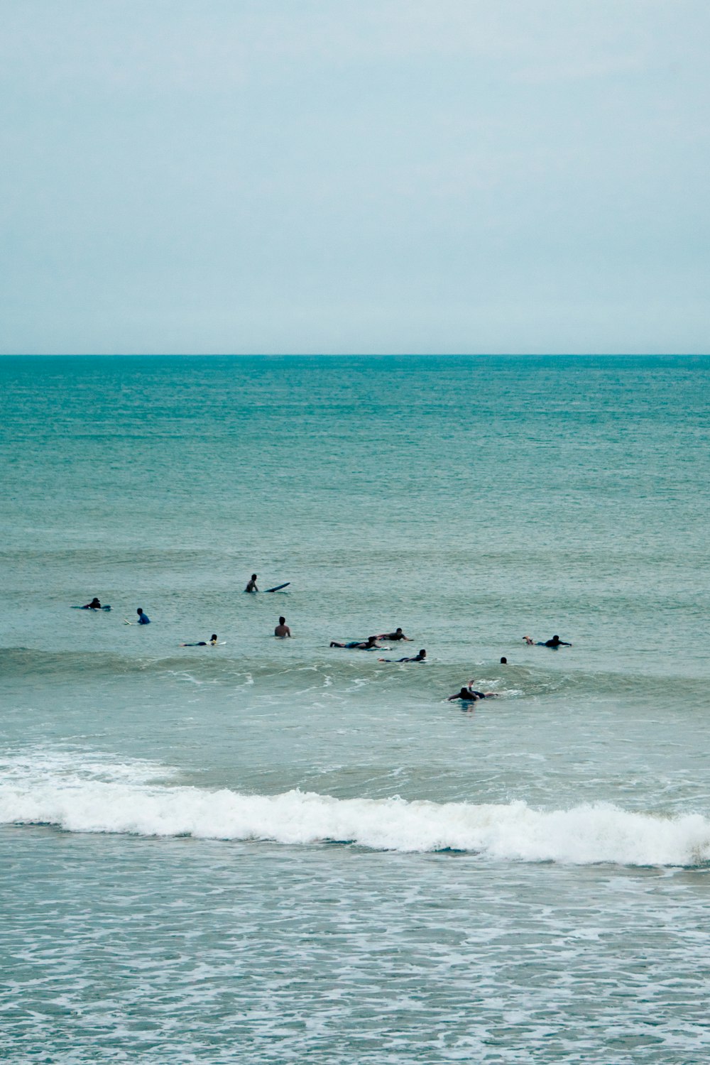 a group of people riding surfboards on top of a wave