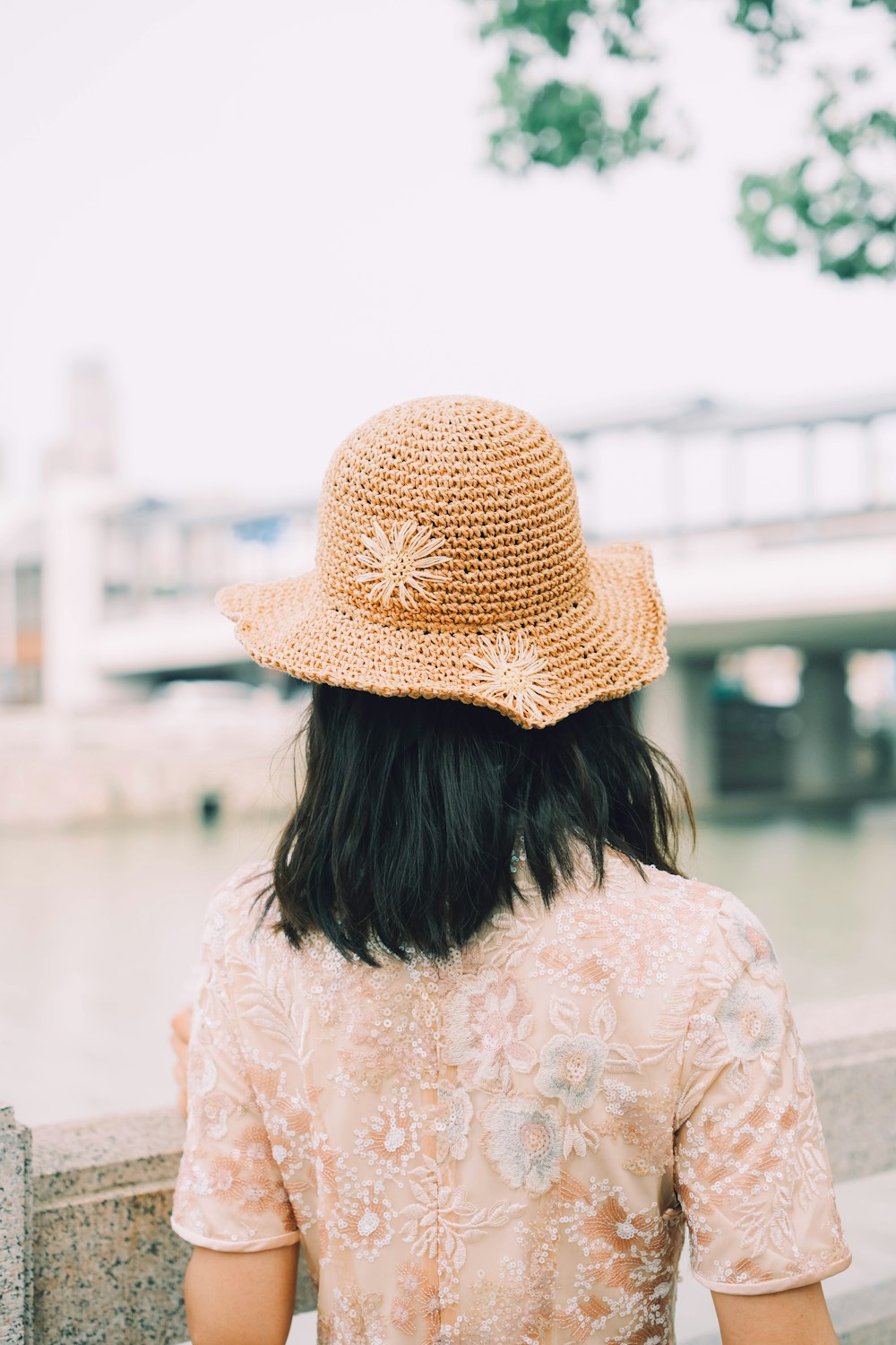 a woman wearing a hat sitting on a bench