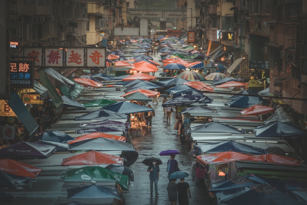 a group of people walking down a street holding umbrellas