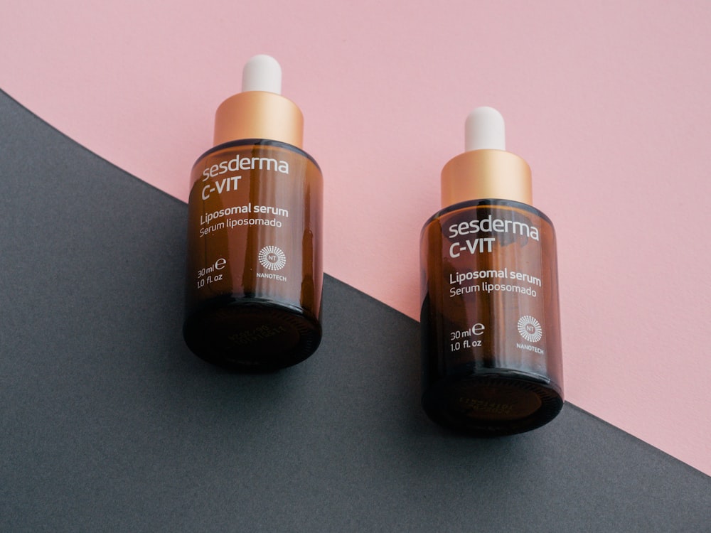 two bottles of gerania vitamin c - lift on a pink and black background