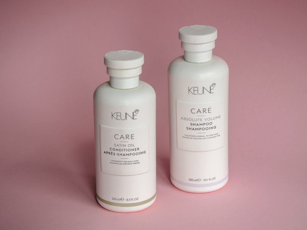 two bottles of keune care on a pink background