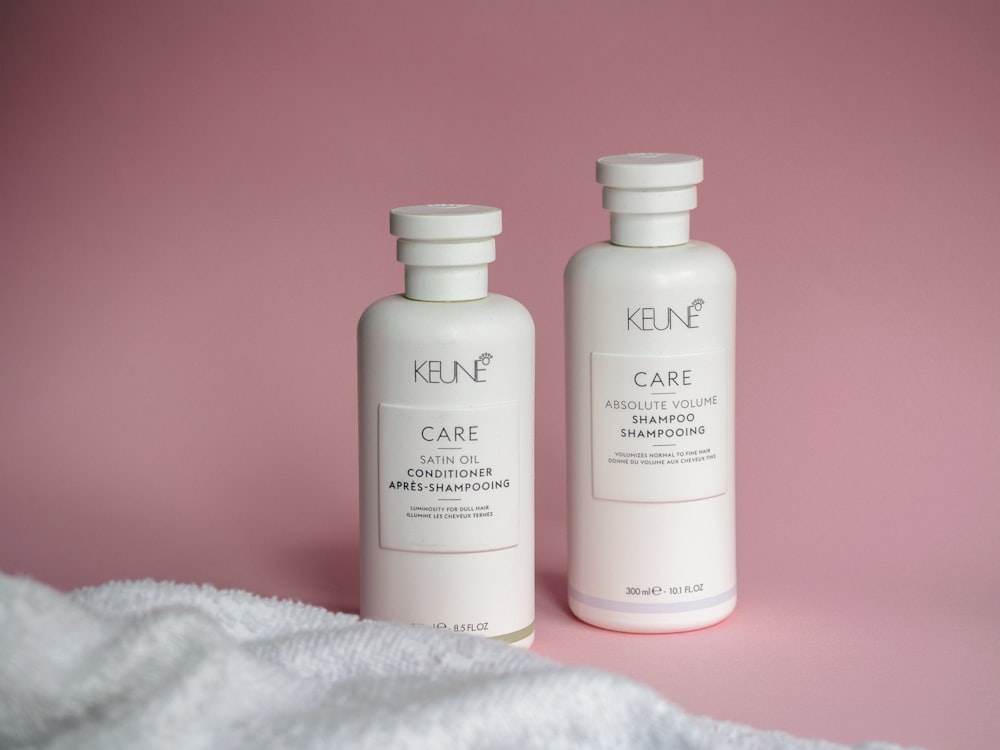 two bottles of keune care on a pink background