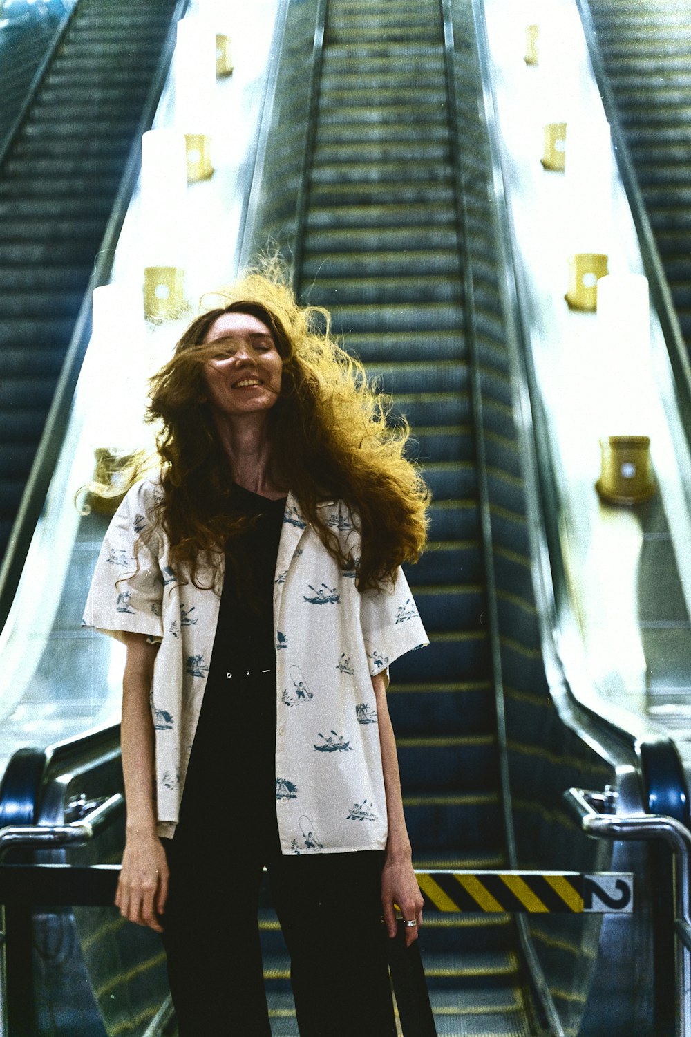a woman standing in front of an escalator