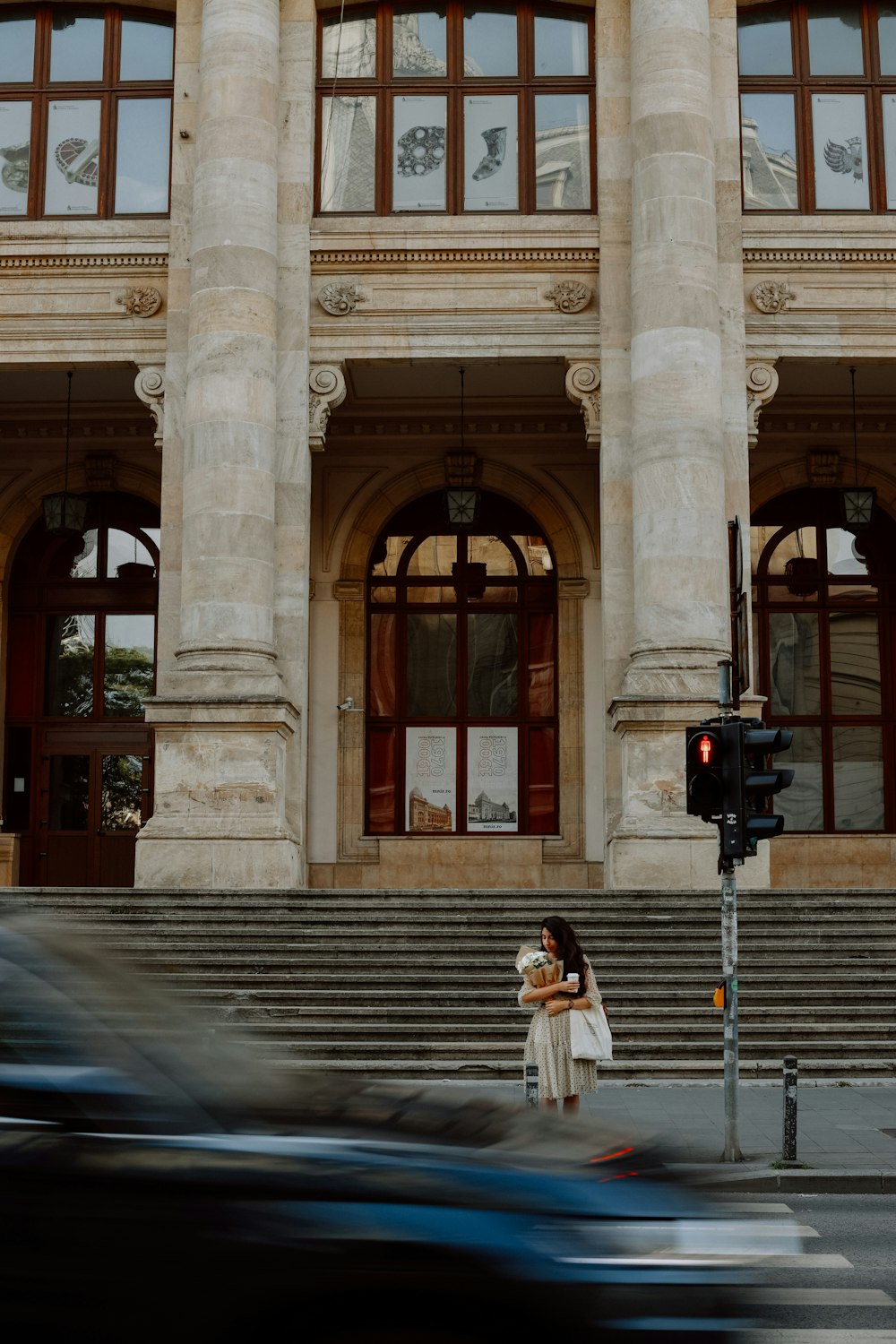 a woman standing in front of a large building