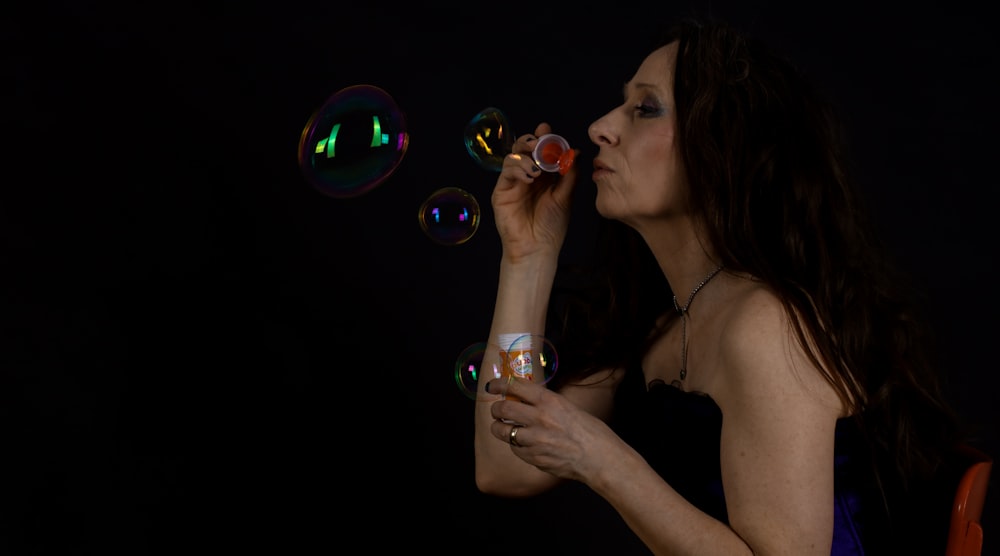 a woman blowing bubbles in the dark