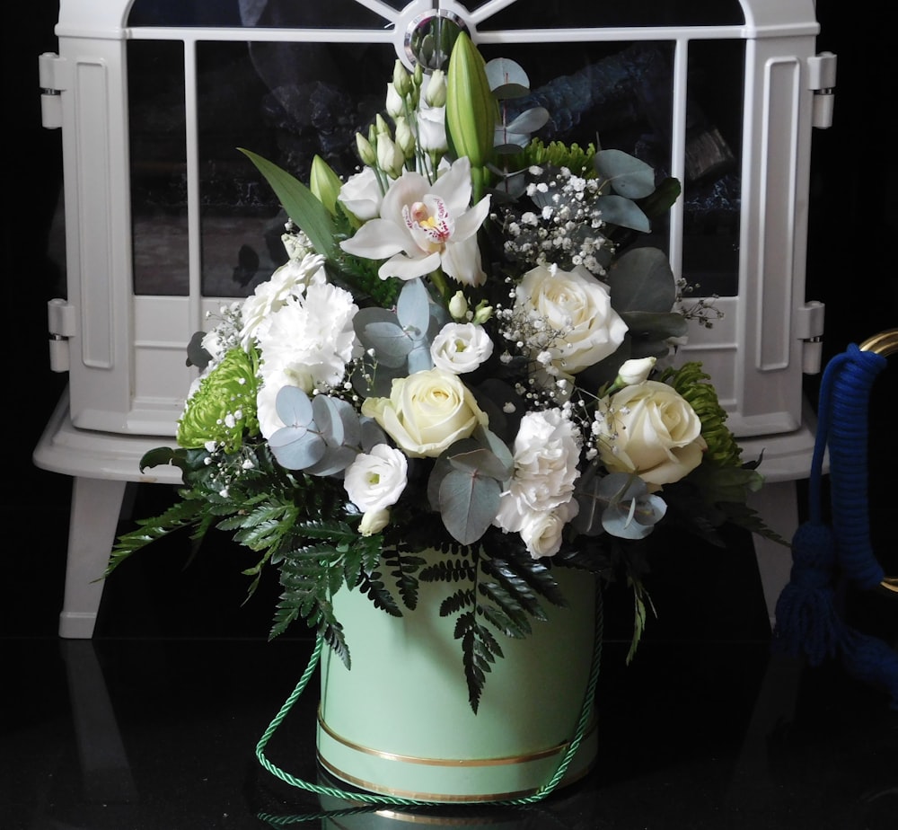 a bouquet of white flowers in a green vase
