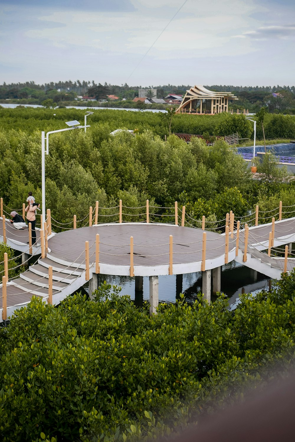 a man standing on top of a circular structure surrounded by trees