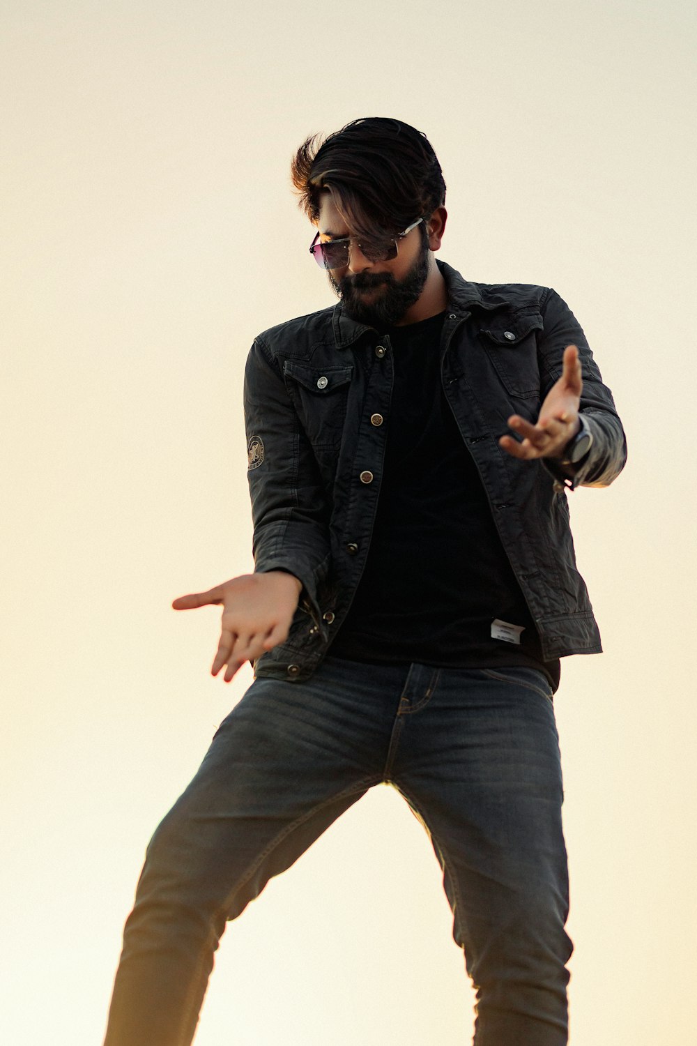 Ein Mann in schwarzem Hemd und Jeans macht einen Trick auf einem Skateboard