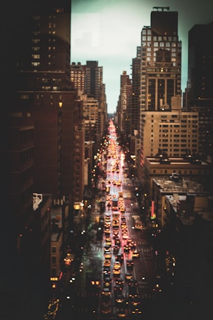 A bustling New York City street with yellow taxis and skyscrapers under a bright sky.