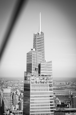 Sleek black and white luxury penthouse exterior at dusk with city skyline backdrop