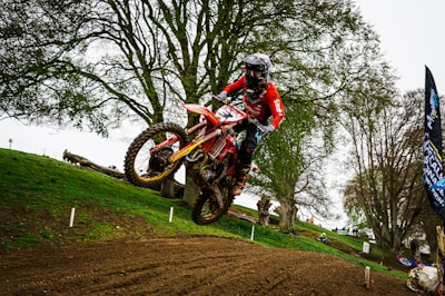 a man riding a dirt bike on top of a dirt field