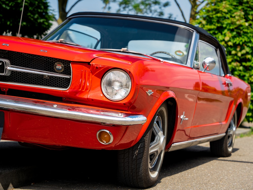 Um carro Mustang vermelho estacionado na beira da estrada