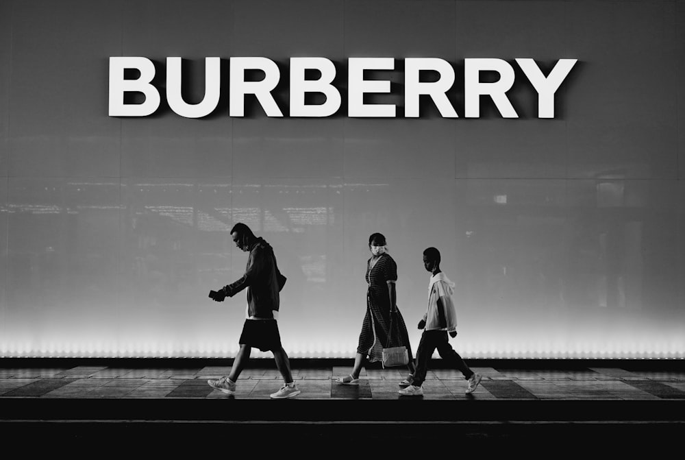 a group of people walking past a store front