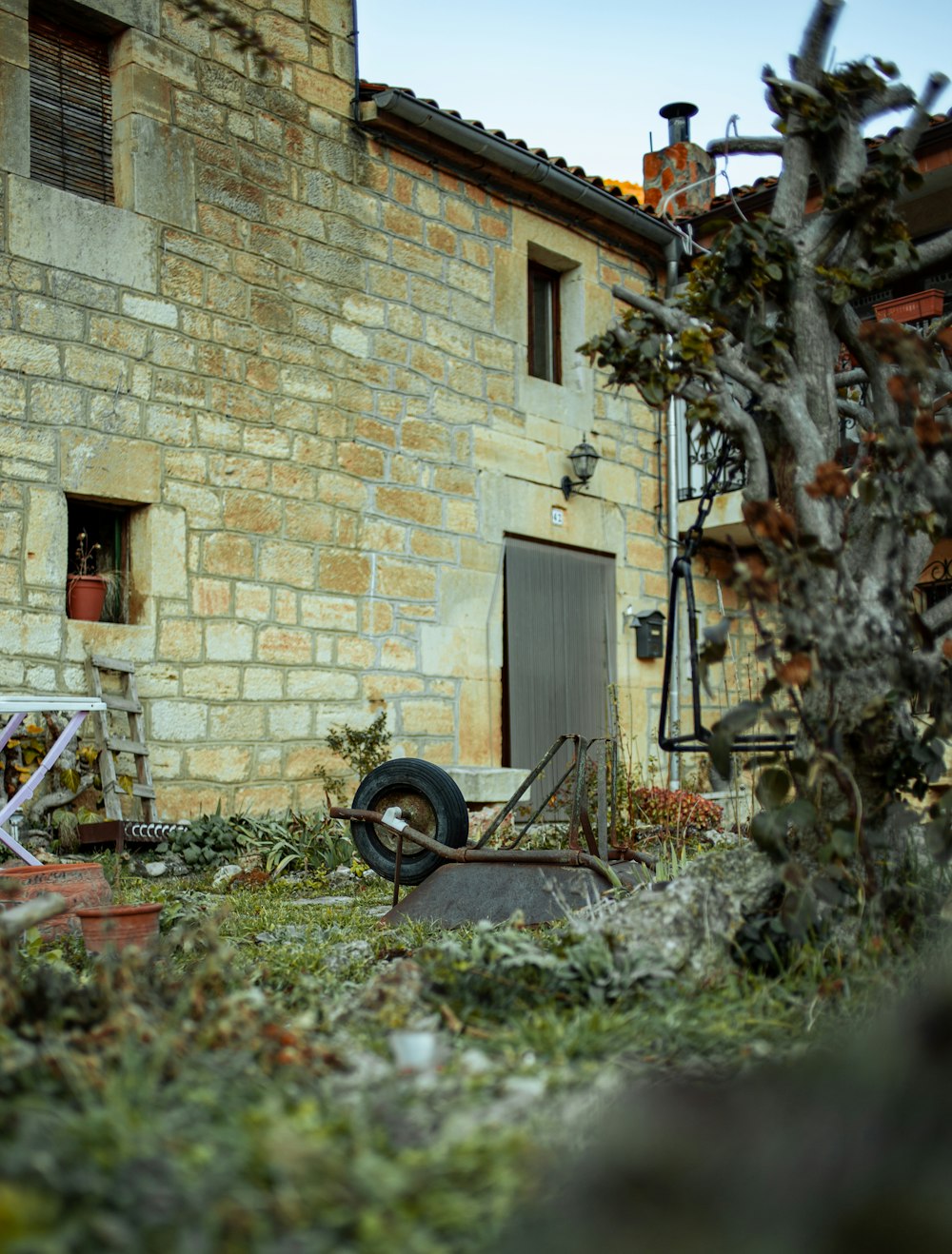 an old building with a wheel and a chair in front of it