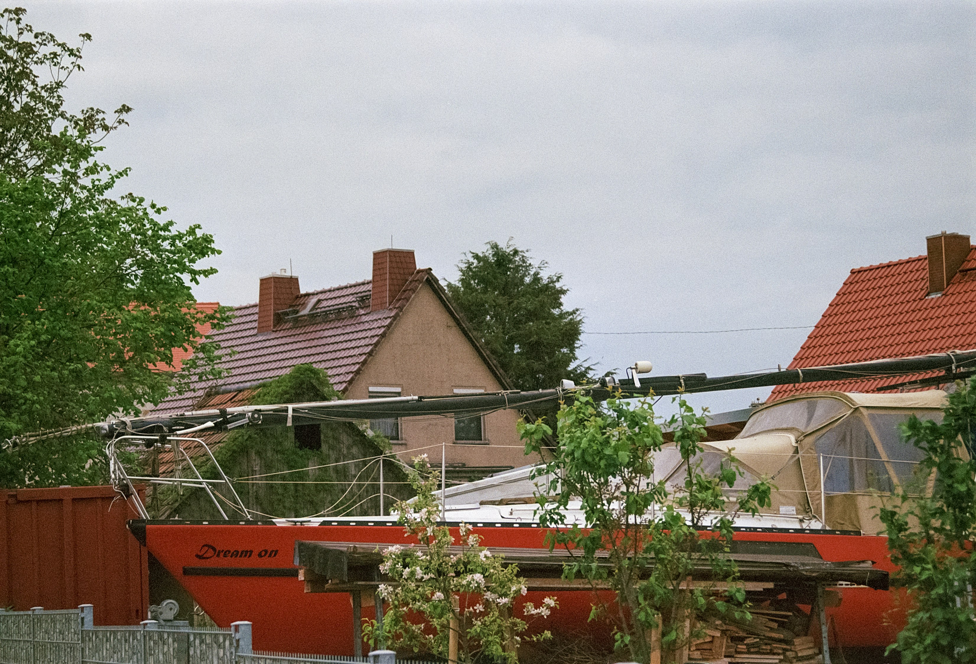 a house with a red roof next to a fence