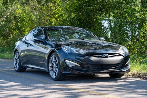 A sleek car parked by a scenic road with lush greenery around Bengaluru.