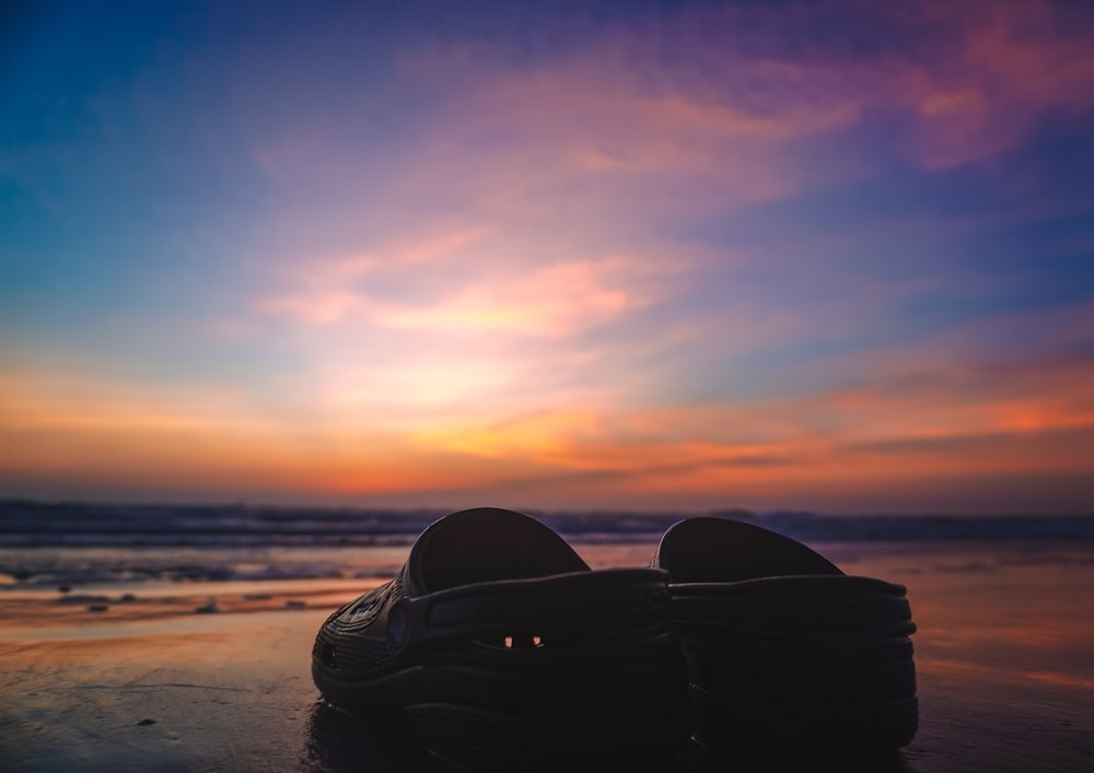 a pair of shoes sitting on top of a beach