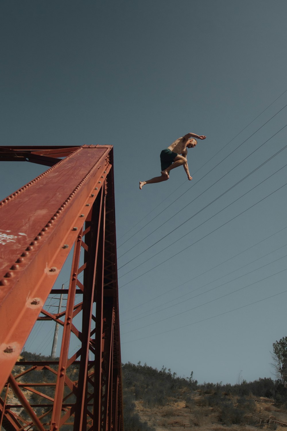 a person jumping off a bridge into the air