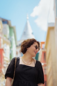a woman in a black dress is standing in the street