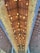 A ceiling structure made from bamboo tubes, arranged geometrically with light bulbs suspended in rows, creating a warm and symmetrical atmosphere. The overall design emphasizes the natural texture of bamboo and provides an intricate, artistic pattern.