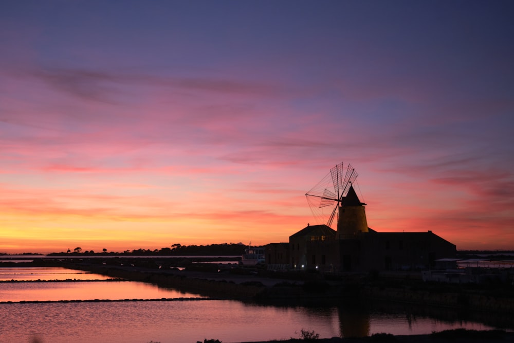 a windmill sitting next to a body of water