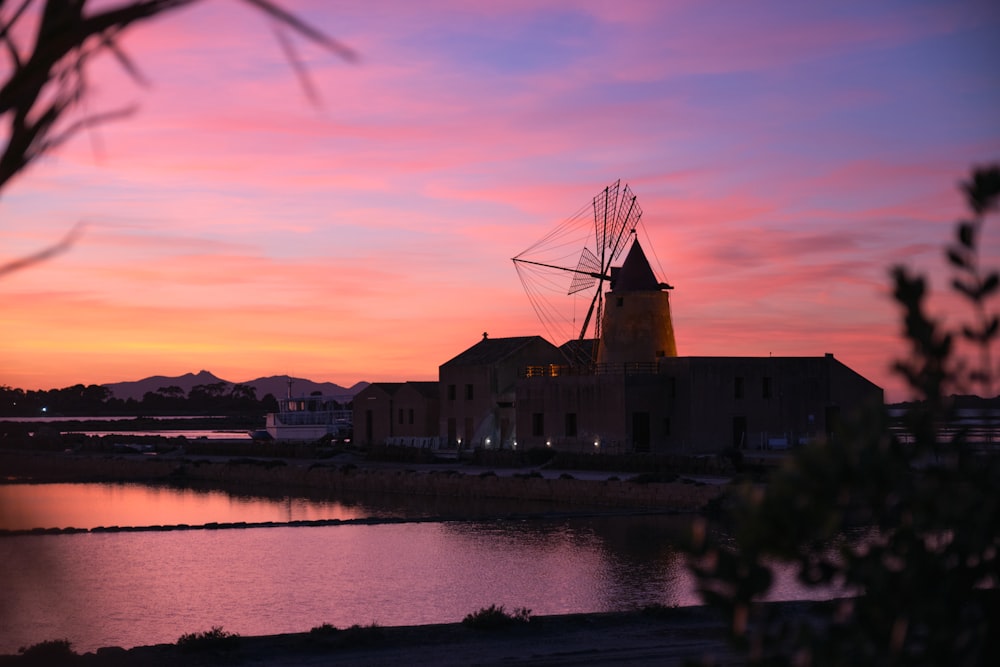 a windmill sitting next to a body of water