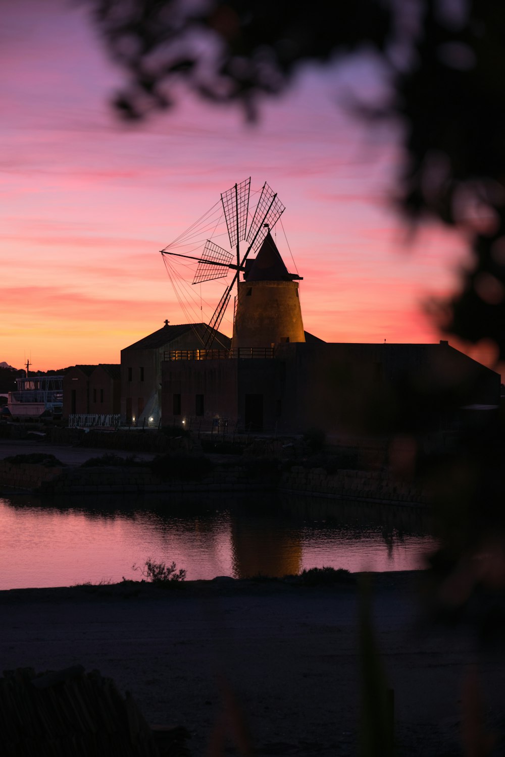 a windmill sitting next to a body of water