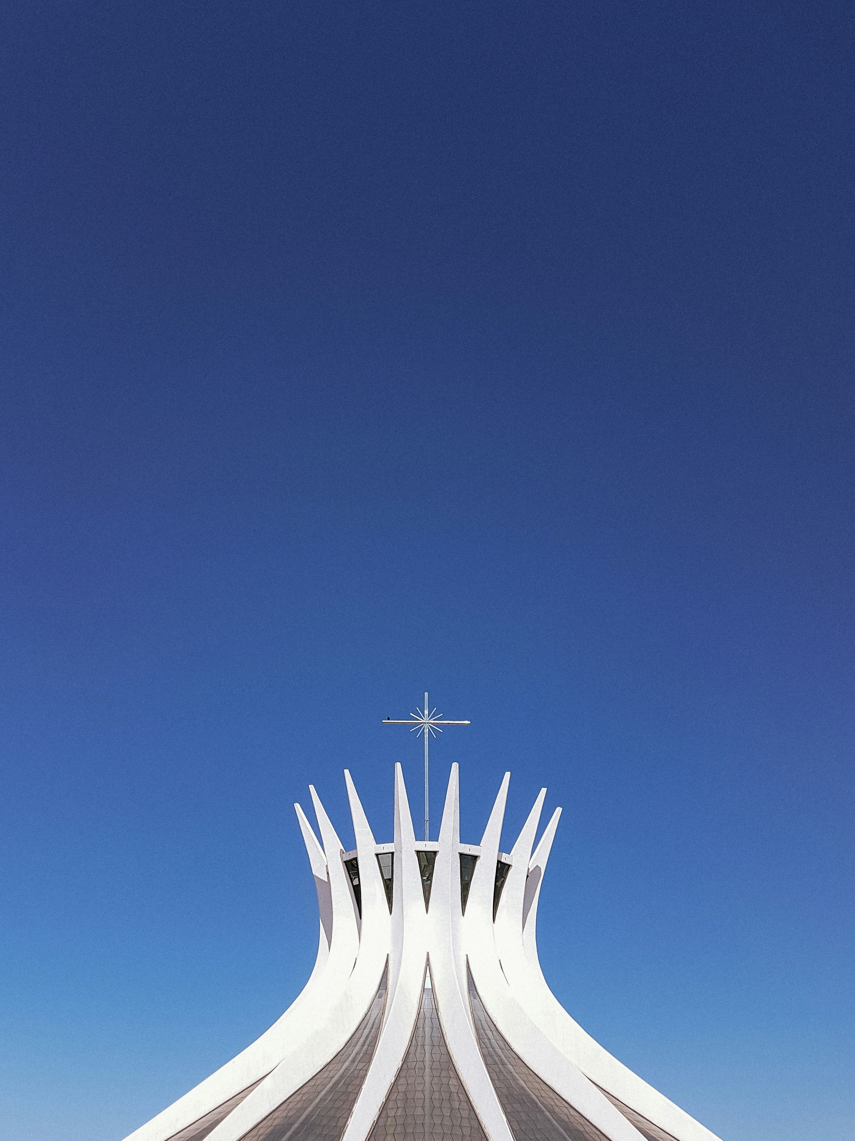 a tall white building with a cross on top of it