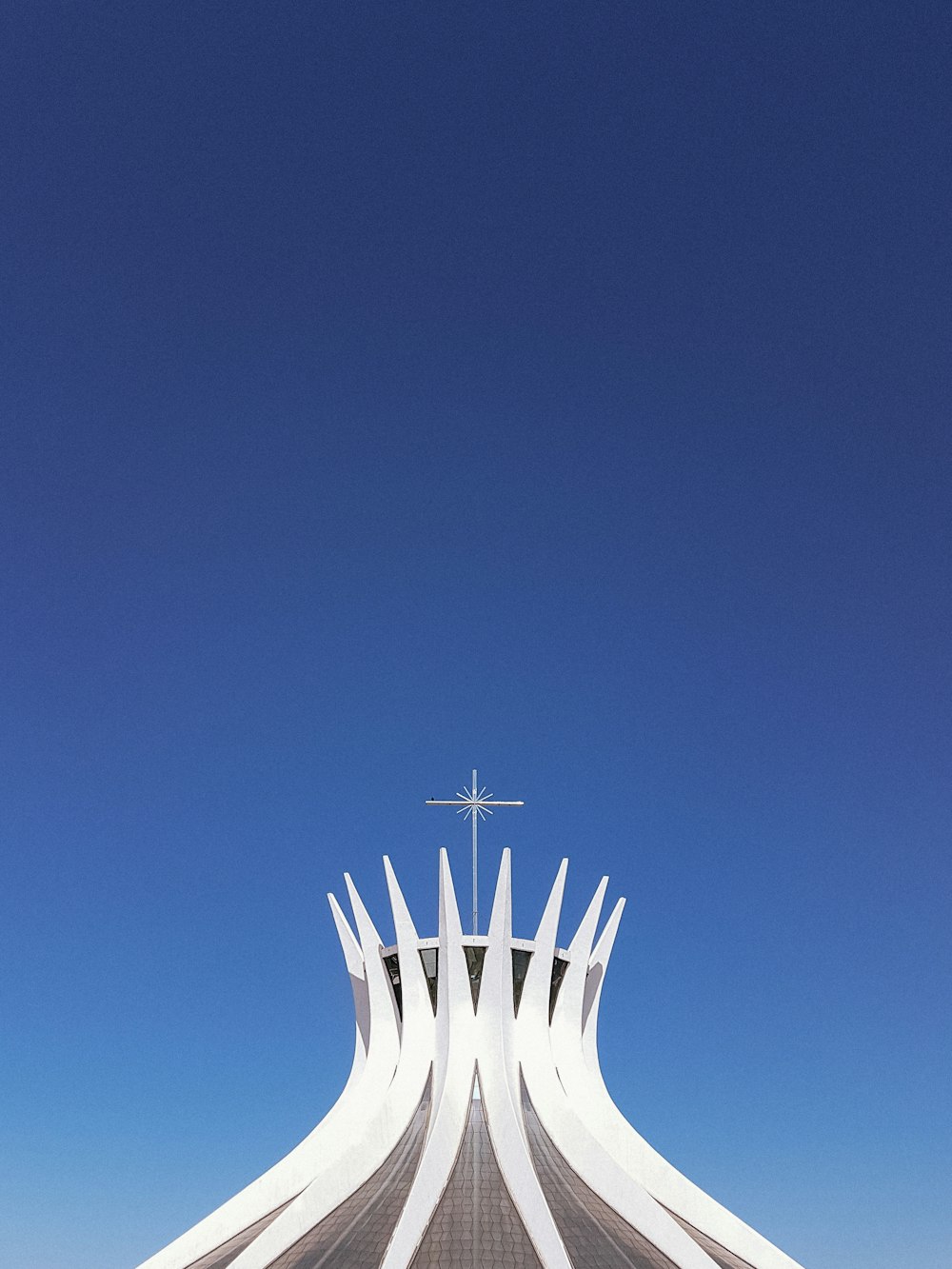 a tall white building with a cross on top of it