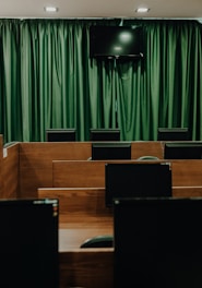 a room with rows of desks and a flat screen tv