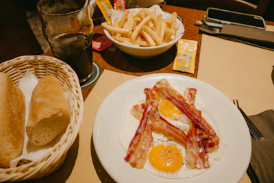Happy customers enjoying a hearty western-style breakfast with crispy bacon in Phnom Penh café.