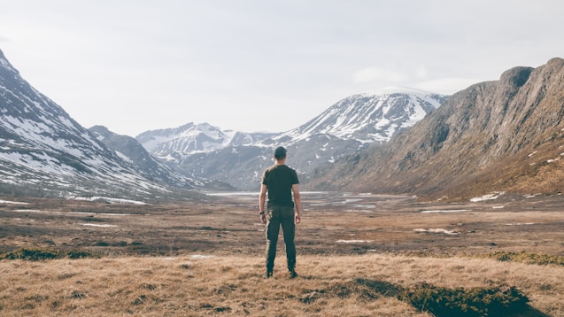 a man standing on top of a dry grass field