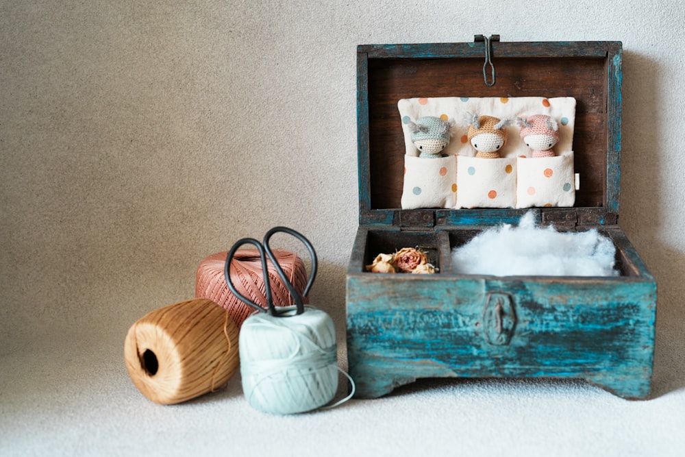 a wooden box filled with balls of yarn