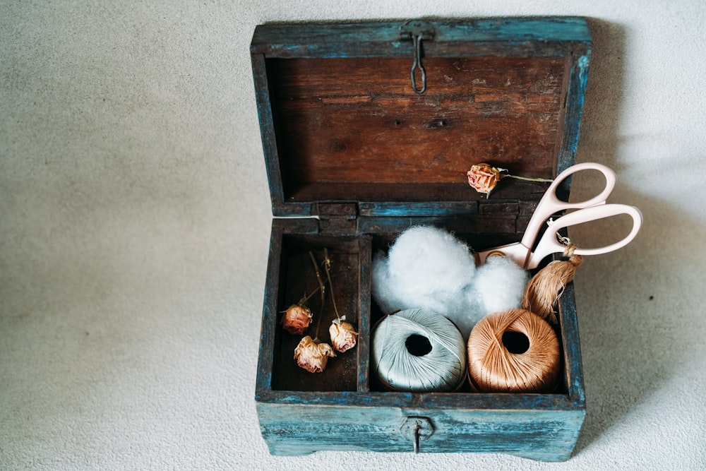 a wooden box filled with yarn and a pair of scissors