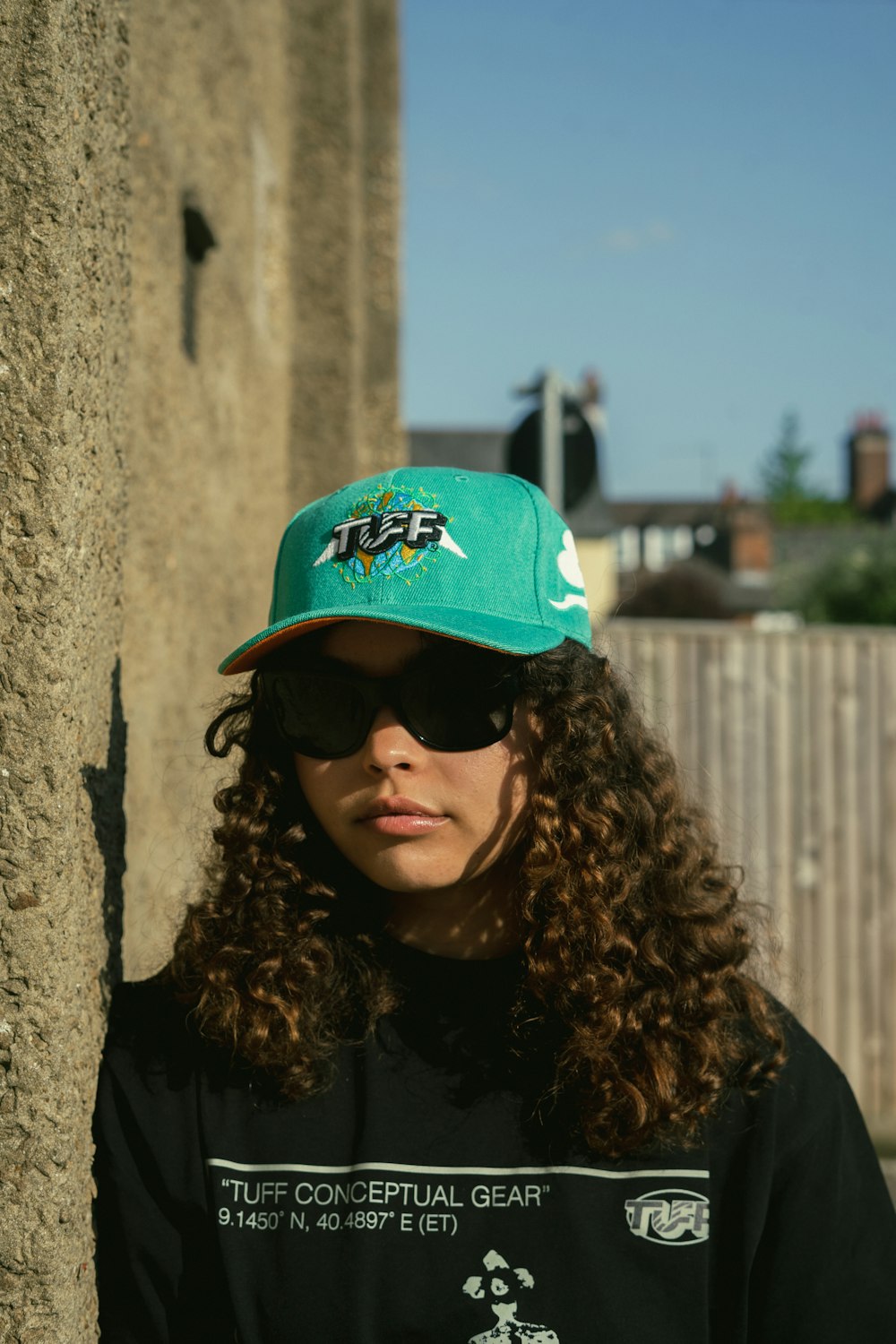 a woman wearing a black shirt and a green hat