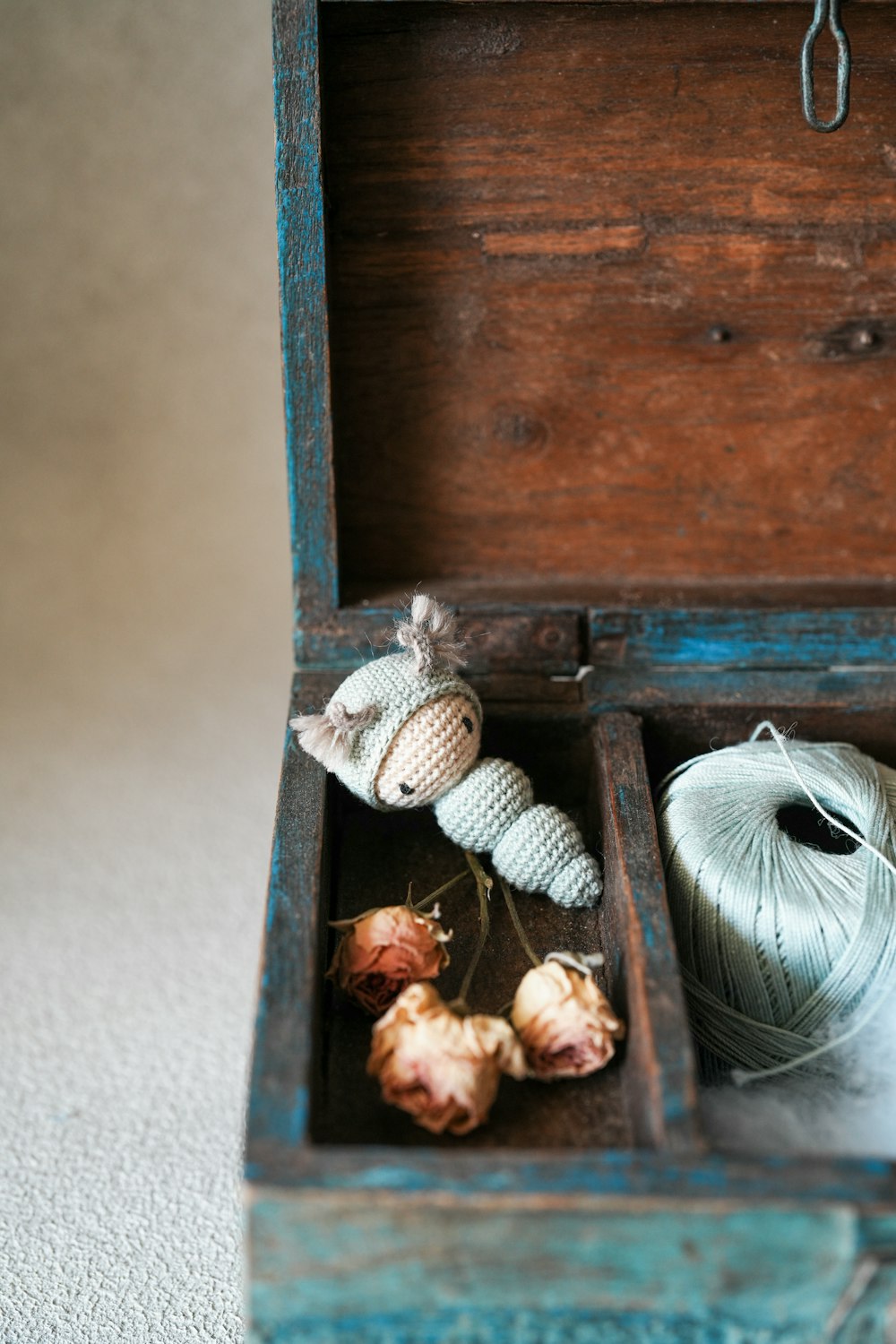 a wooden box filled with yarn and a ball of yarn