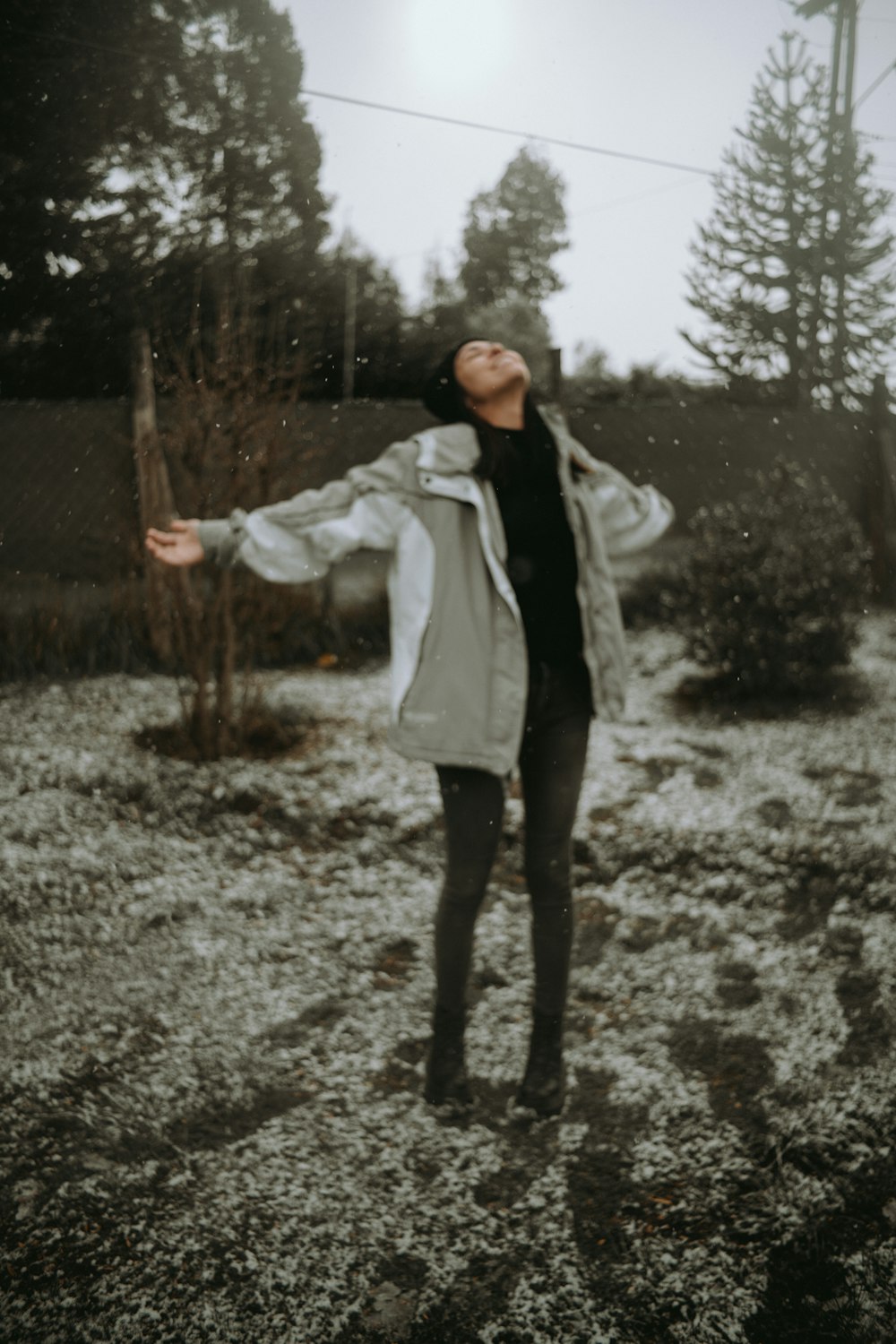 a woman standing in a field with her arms outstretched