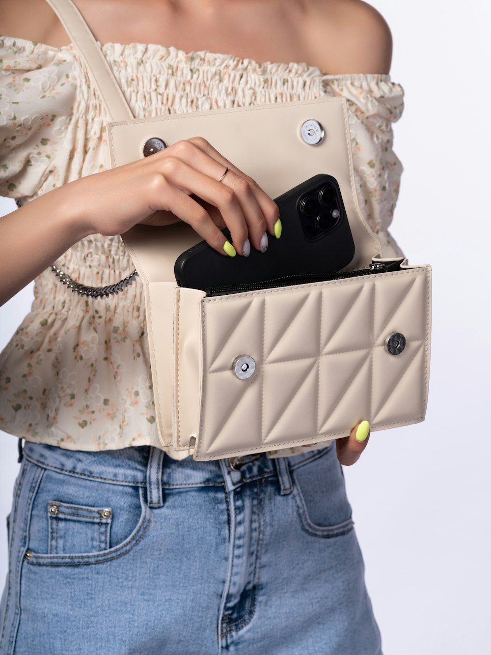 a woman holding a cell phone in a purse