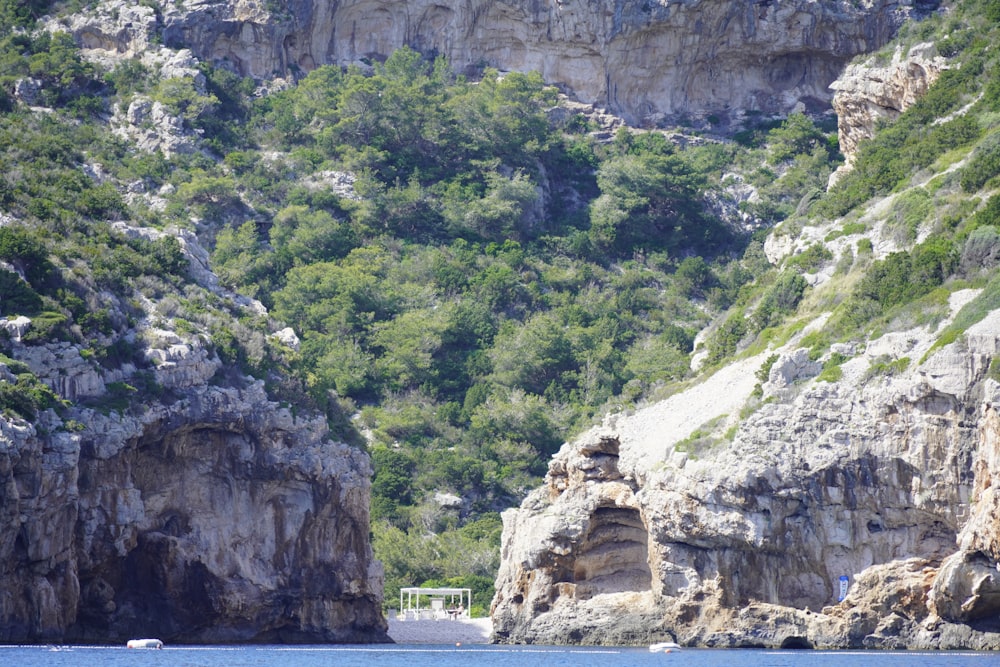 a large body of water surrounded by a lush green hillside