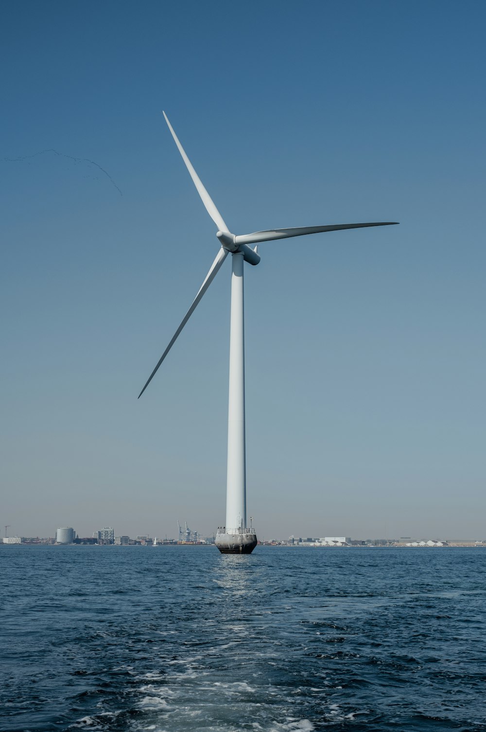 a large wind turbine on top of a body of water