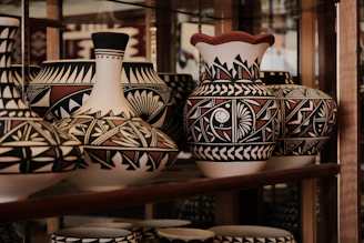 a shelf filled with lots of vases on top of a wooden shelf