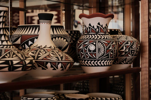 a shelf filled with lots of vases on top of a wooden shelf