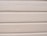 Several horizontal beige siding panels with visible signs of peeling paint and surface wear.