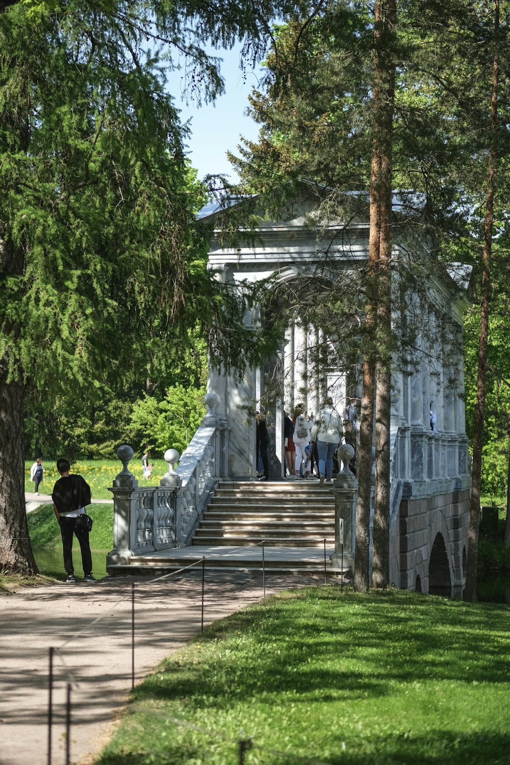 a group of people walking down a sidewalk next to a building