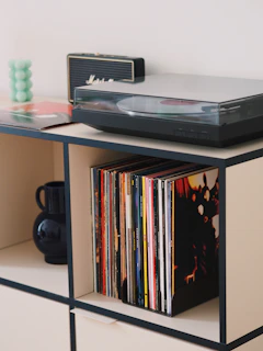 Sleek industrial metal media stand holding a vintage record player and stacks of vinyl.
