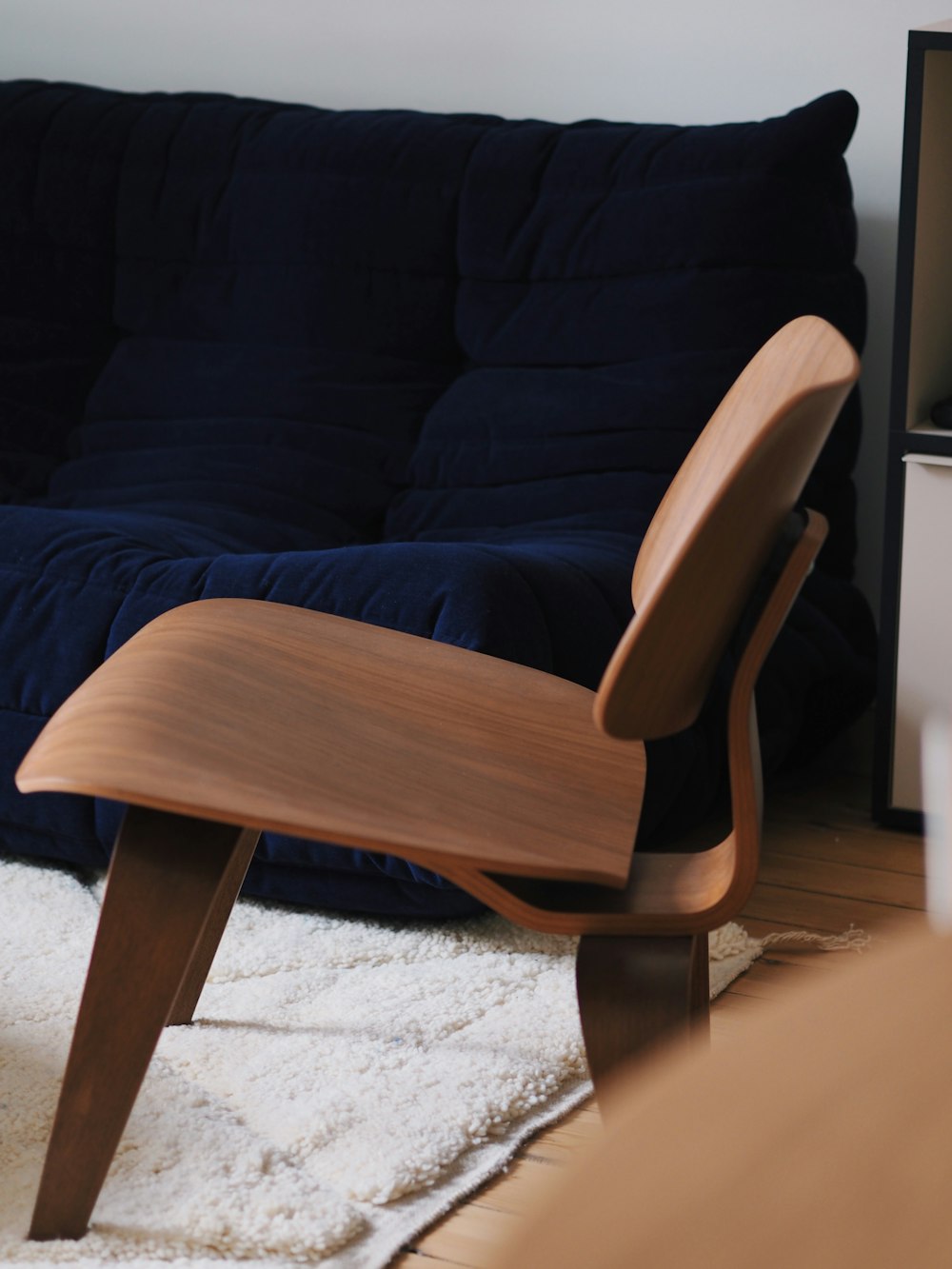 Una silla de madera sentada encima de una alfombra blanca