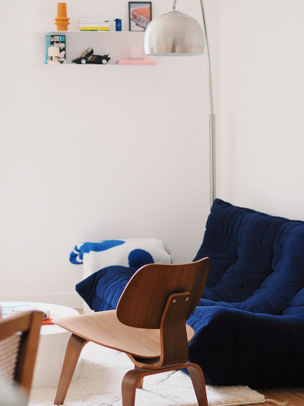 una sala de estar con una silla azul y una alfombra blanca