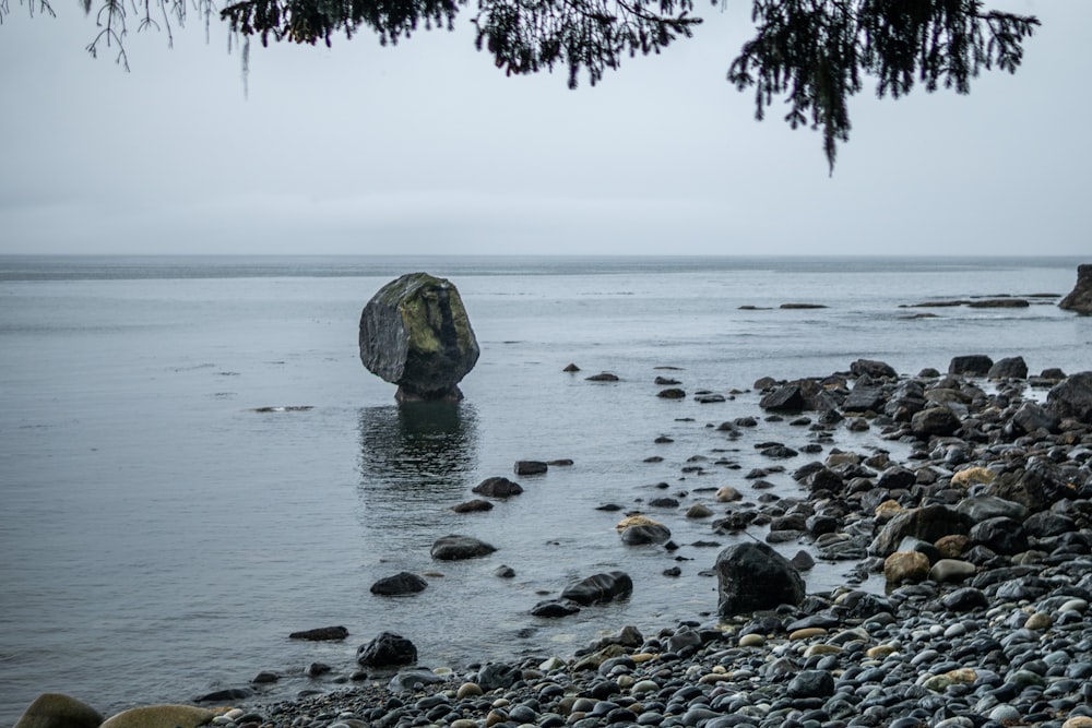 a large rock in the middle of a body of water